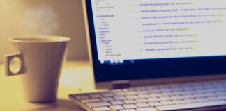 computer monitor displaying Craiglist website with keyboard, pencil, and coffee mug