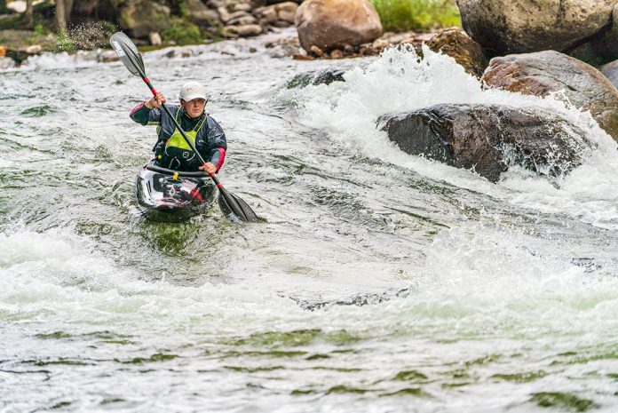 Man paddling black whitewater kayak