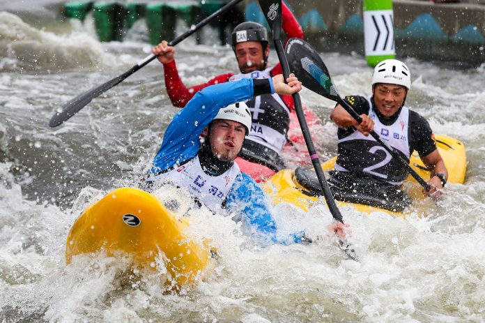 Three whitewater kayaks jostling for position in the waves.