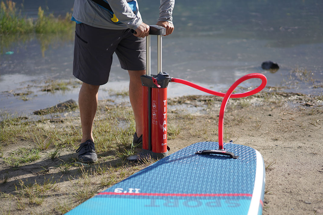 Man pumping up paddleboard.