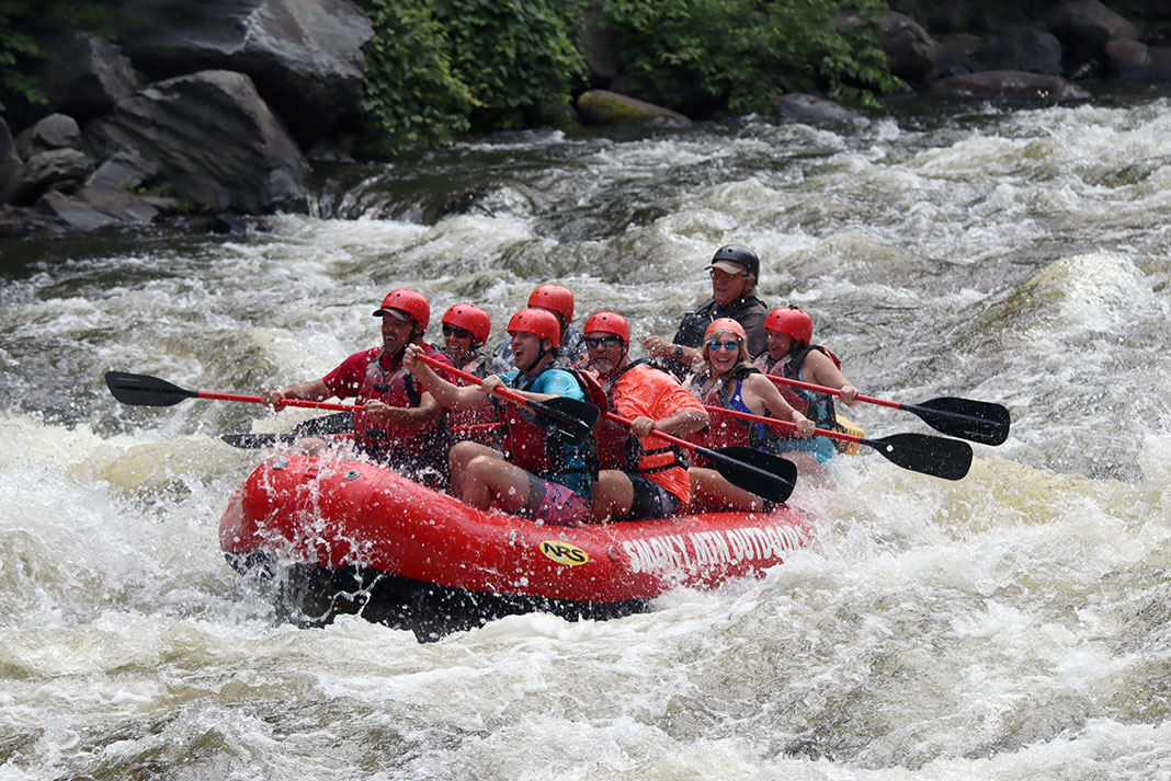 people in a whitewater raft go on a river trip