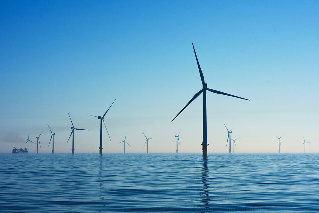 wind turbines rise out of the ocean water