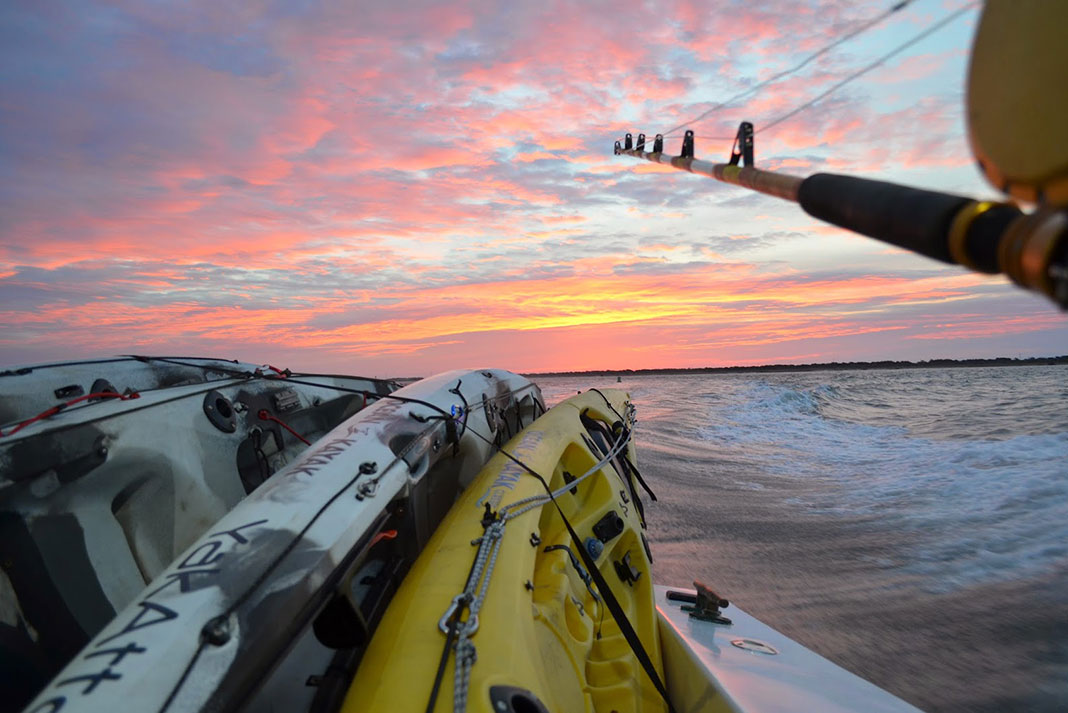 kayaks are tied and transported on a mothership at dawn during a kayak fishing trip