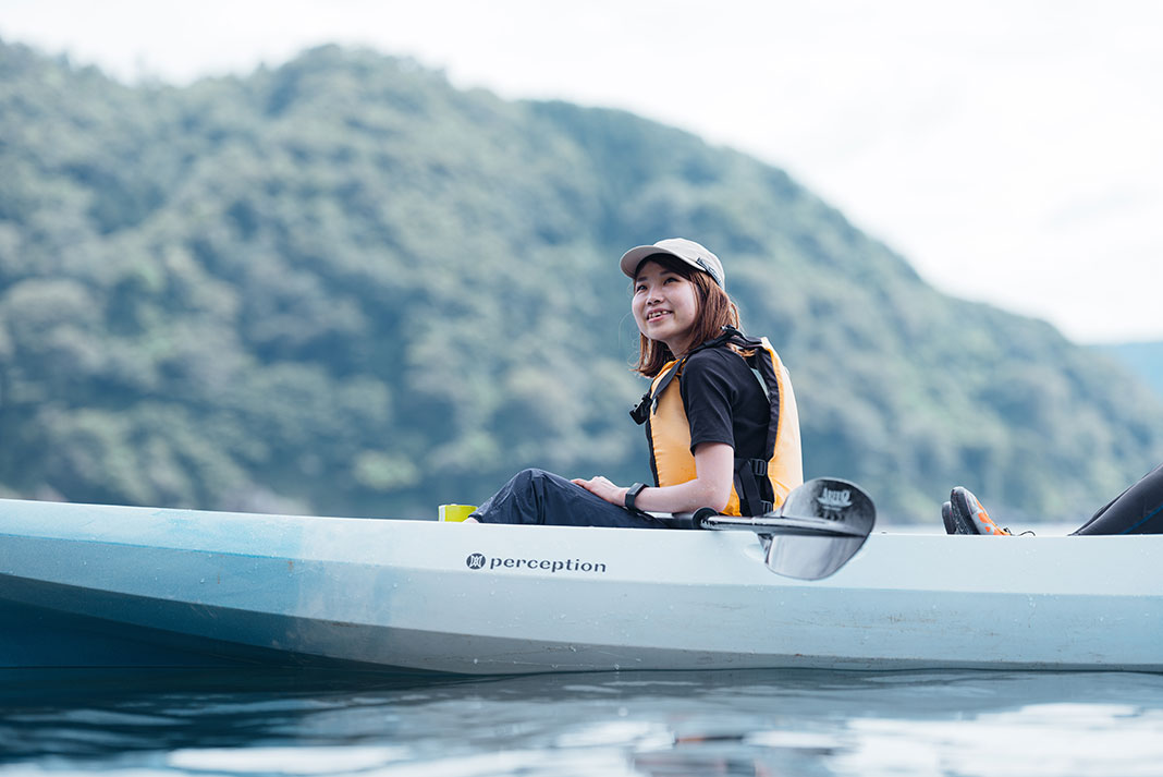 woman smiles while kayaking in Wakasa Bay, Japan