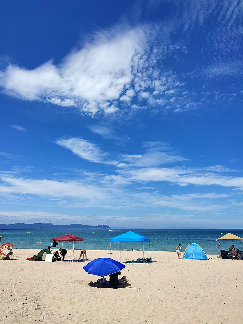 umbrellas and people on Suishohama Beach in Wakasa Bay, Japan
