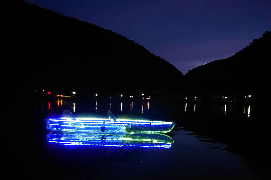 a clear kayak lit up with LED lights in Wakasa Bay, Japan