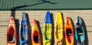 group of kayaks of different sizes lined up outside a building