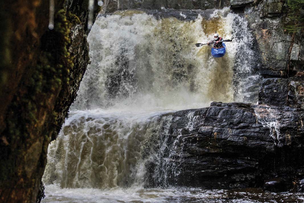 whitewater kayaker descends a large waterfall