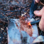 Skill: Master the No-Match Fire A close up of a spark hitting dry tinder from a flint and steel tool