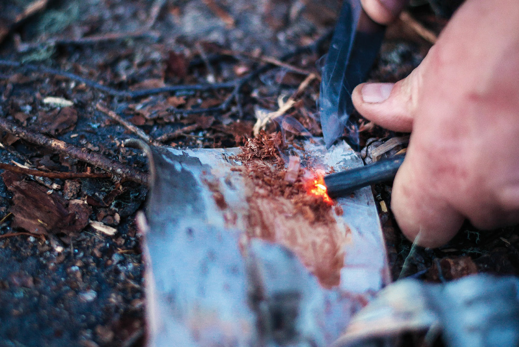 A close up of a spark hitting dry tinder from a flint and steel tool