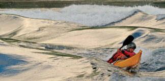 sea kayaker paddles in waves