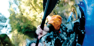 underwater shot of a person completing a whitewater kayak roll