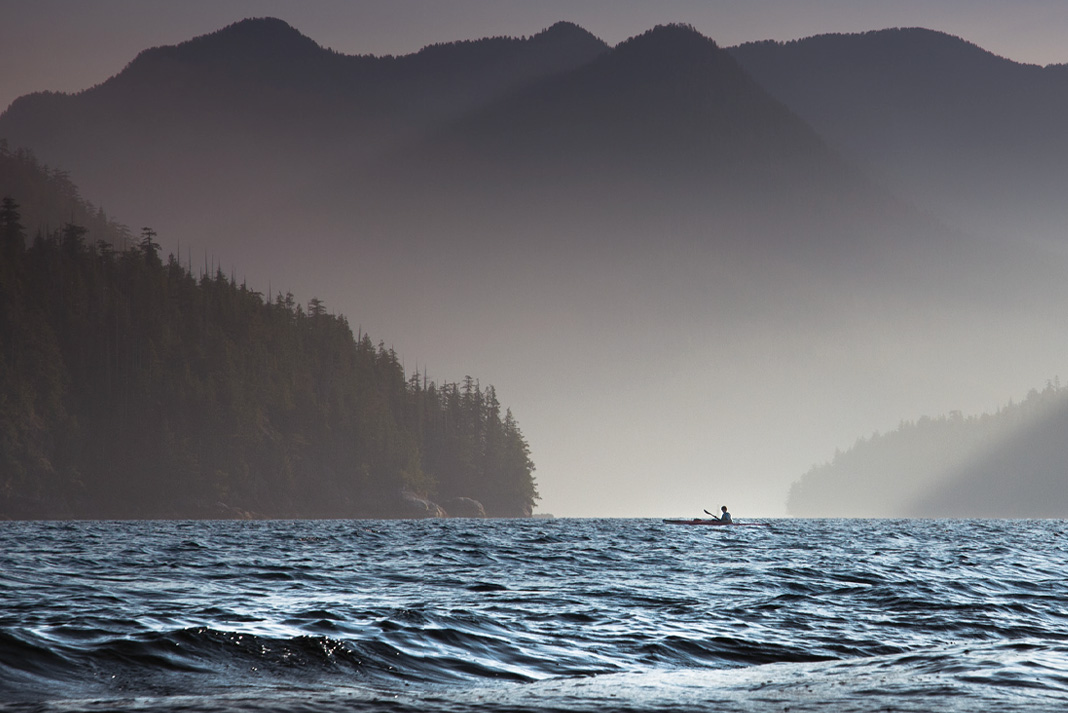 The dramatic fjords of Clayoquot Sound humble a lone paddler. | Photo: Sander Jain