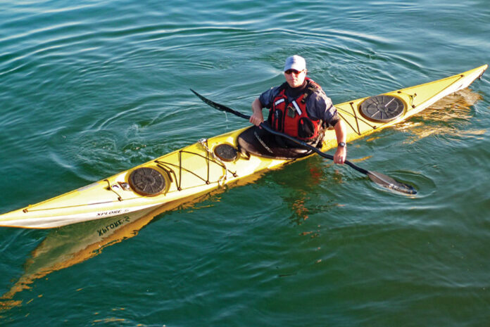 Man paddling yellow sea kayak