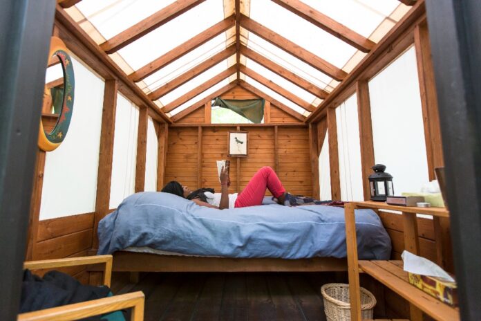 woman reads in the interior of a bright cabin in Algonquin Park