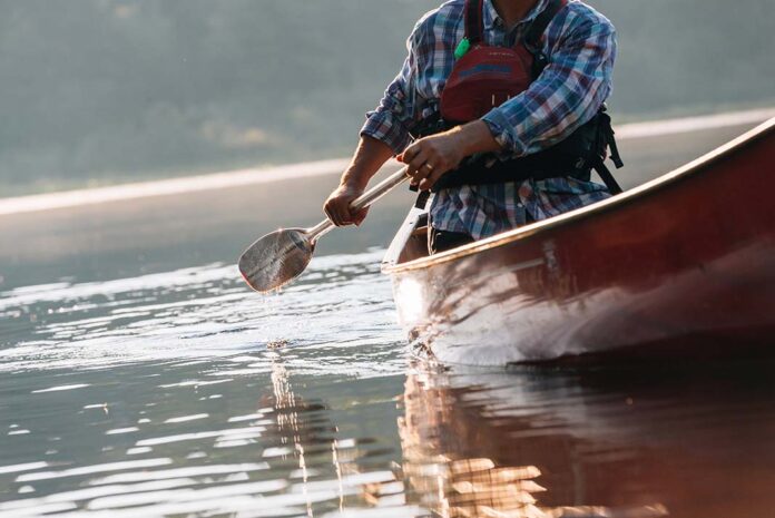 A paddler solo canoes across a lake in Algonquin Park
