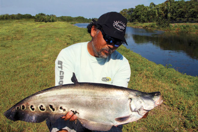 Alberto Knife poses with a clown knifefish he caught