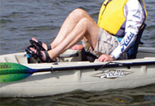 person demonstrates how to adjust the fit of a pedal kayak