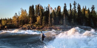 Ben Marr surfs a wave on the Nelson River in Manitoba at sunrise