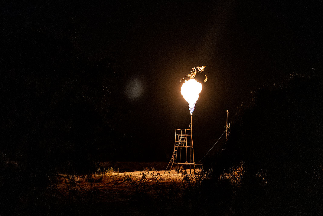 A Texas oil rig lights up with a gas flare in the night