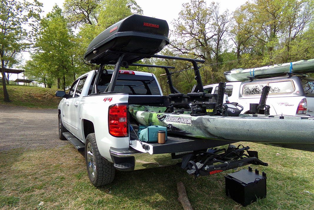 Jackson fishing kayak loaded onto the back of a pickup truck with Yakima racks