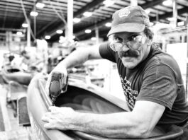 man works on a kayak on the Old Town assembly line