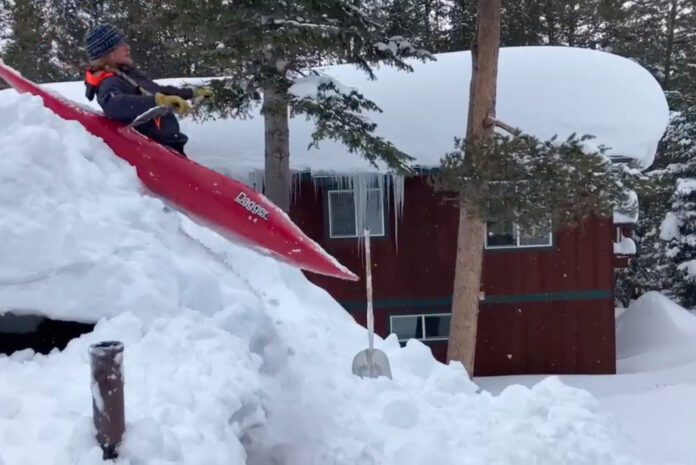Kayaker launches off roof in snow-buried California.