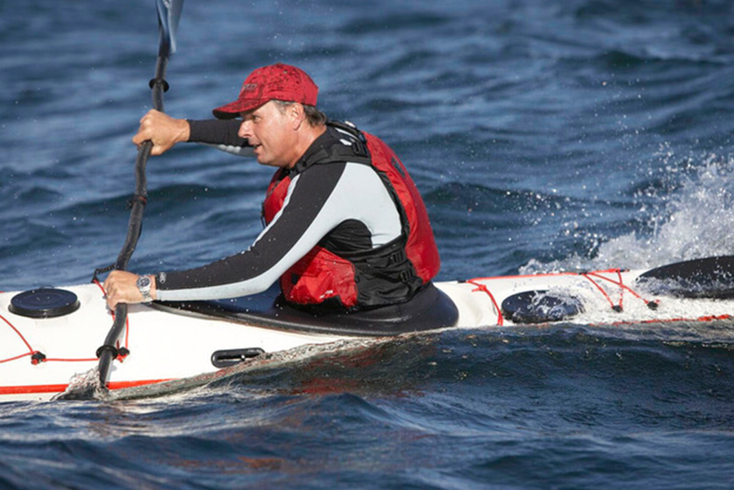 Man paddling a kayak.