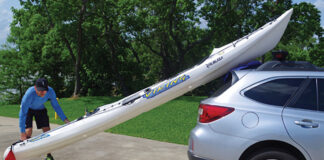 man demonstrates how to lift a kayak onto a vehicle