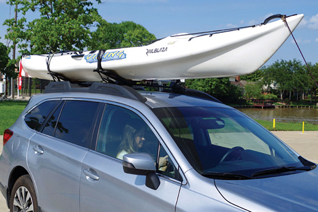 man demonstrates how to lift a kayak onto a vehicle