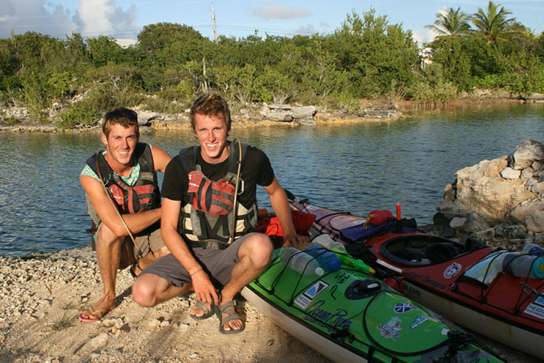 Russell and Graham Henry pose beside the kayaks from their expedition