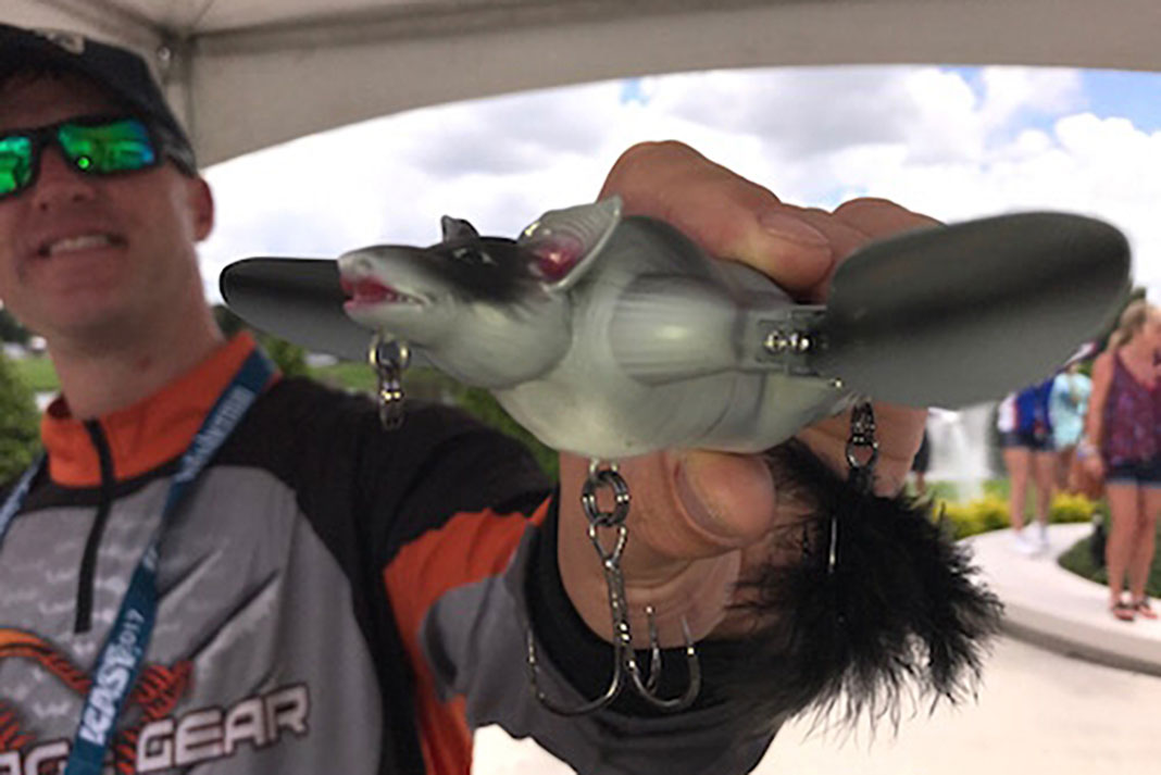 man holds up the Savage 3D Topwater Bat fishing lure