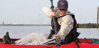 man on red kayak demonstrates the draw stroke