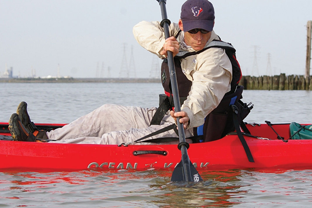 man on red kayak demonstrates the draw stroke