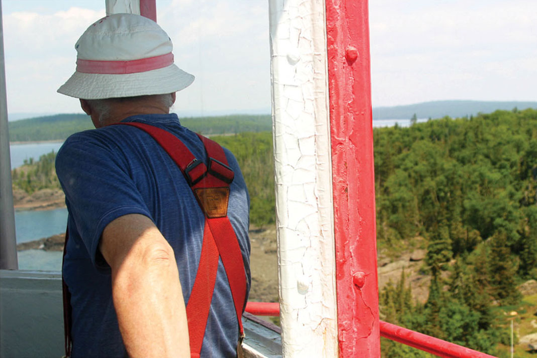 retired Lake Superior lighthouse keeper surveys land and water from the tower