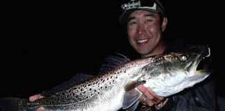 Rob Choi holds up a speckled trout caught with night fishing tactics