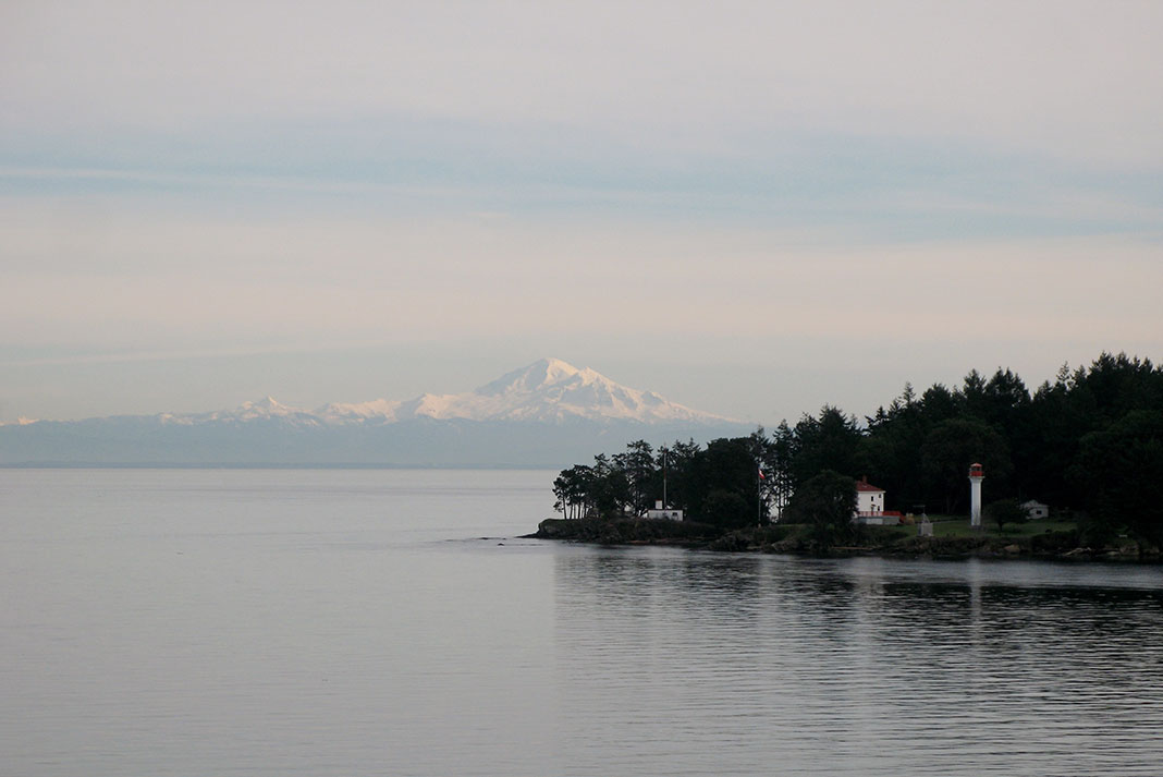 the edge of Mayne Island in BC's Southern Gulf Island, with mountains in the background