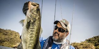 man holds up a bass caught while fishing with a Texas rig