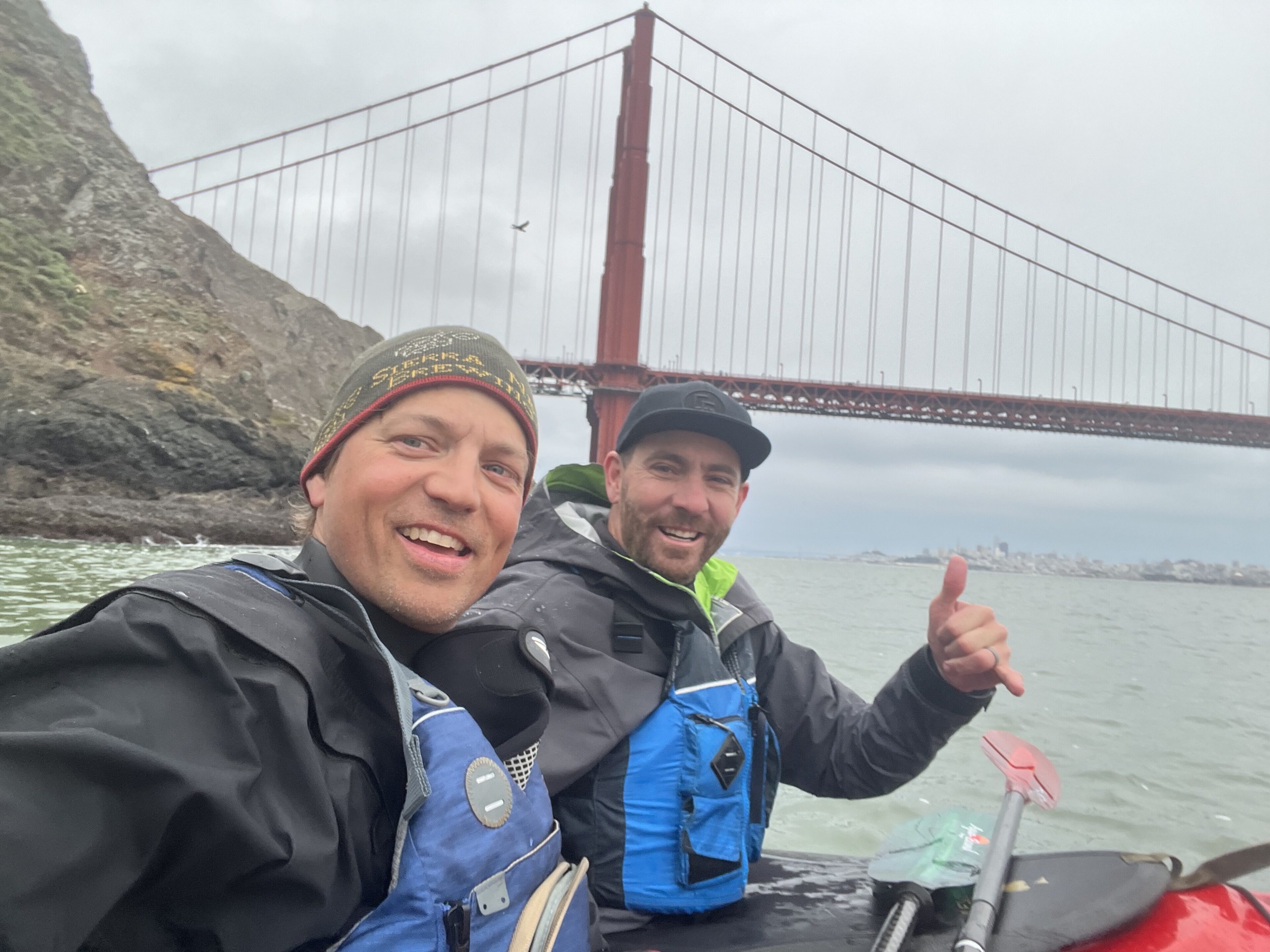 Two men take selfie in sea kayaks.