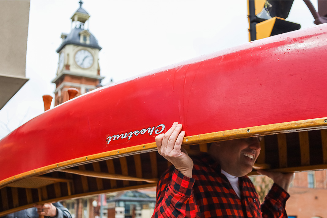 Man portaging a red canoe