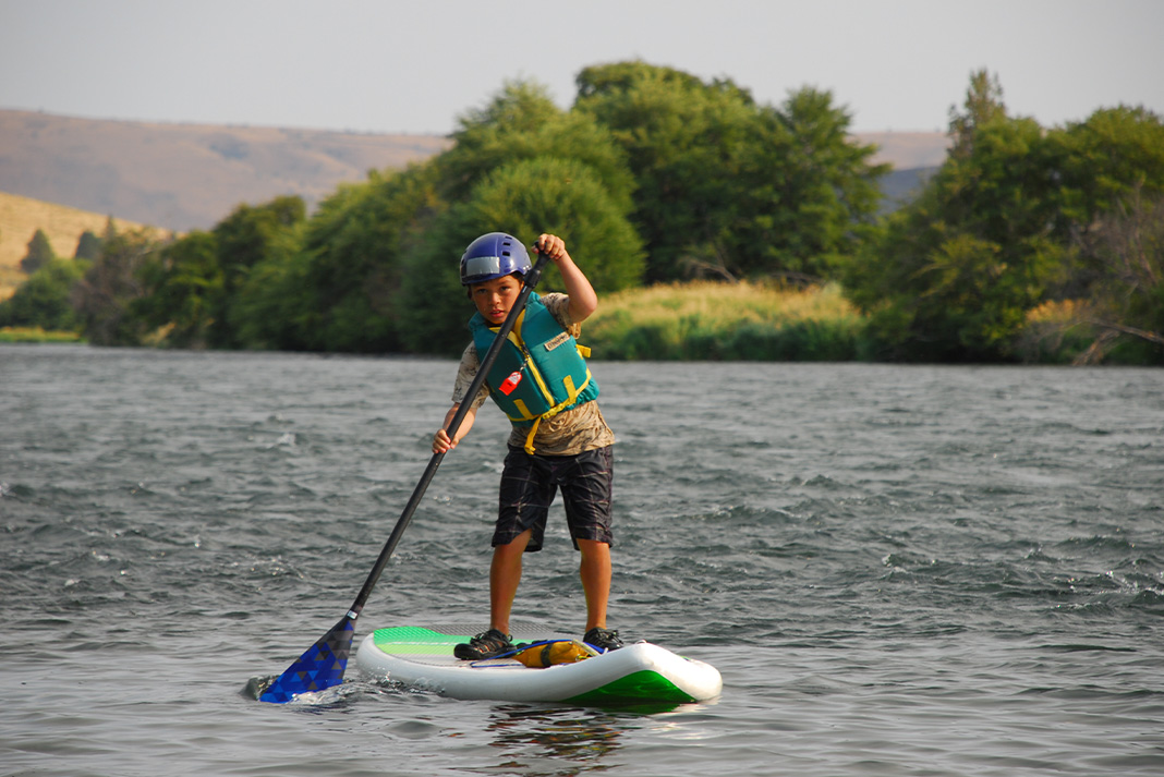 Little boy on a paddleboard.