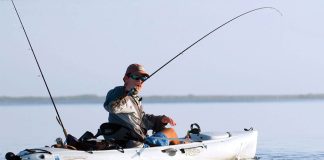 kayak angler uses pro tips to reel in a fish caught with a jerkbait lure