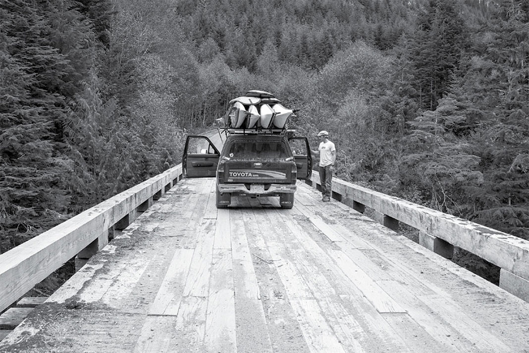 vehicle with kayaks on top on bridge