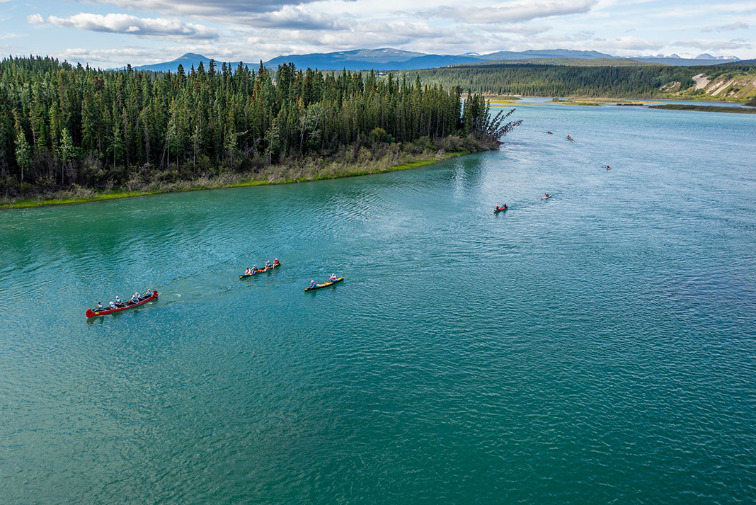 Boats being paddled on Yukon River during the 2023 Yukon River Quest.