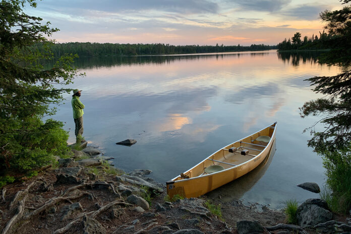 lightweight canoe resting on the glassy river shore at dusk