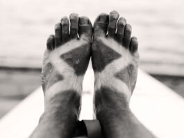 a paddler's deeply suntanned feet in black and white