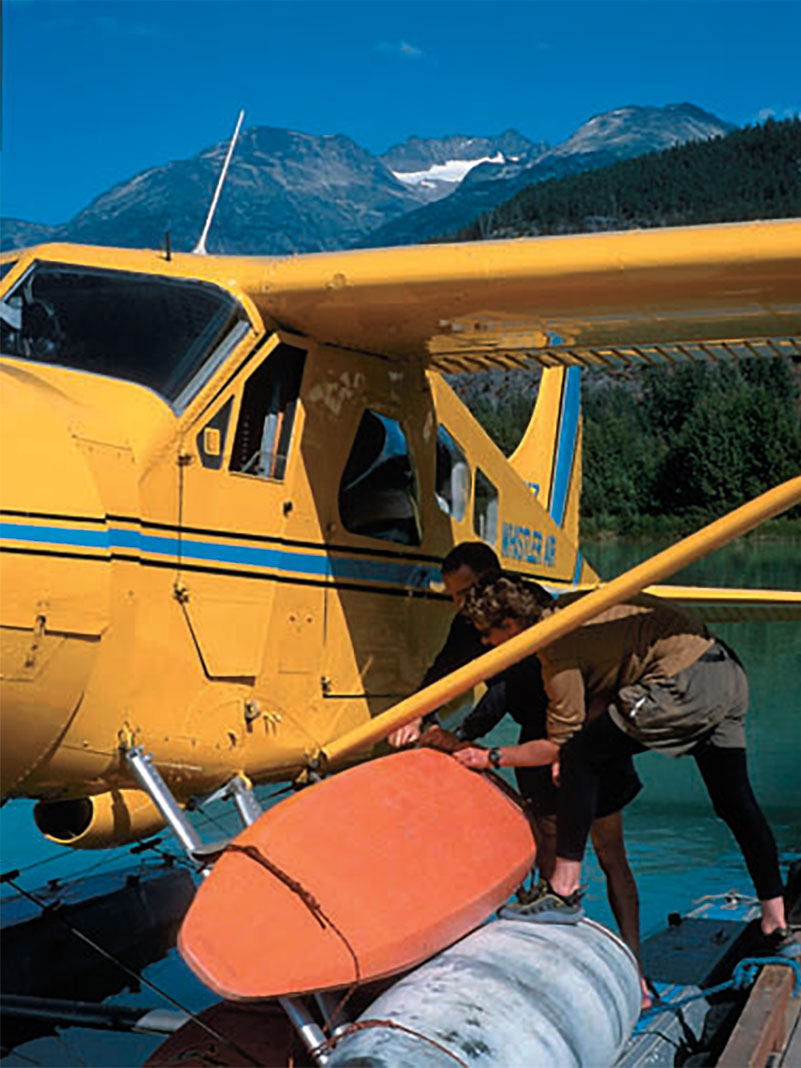 expedition paddler loads kayaks onto a bush plane