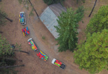 overhead photo of a pair of vans hauling many many river kayaks