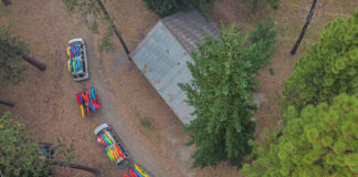 overhead photo of a pair of vans hauling many many river kayaks