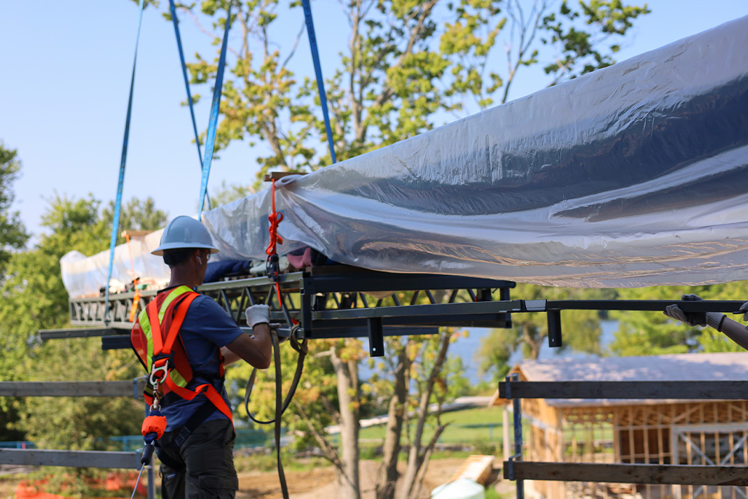 Blue Bird, the longest canoe in The Canadian Canoe Museum’s collection (measuring 16.36 metres), is lifted to the second floor of the new museum and received by a member of the CCM’s team. The canoe will be on display in the new Exhibition Hall. Peterborough-based McWilliams Moving & Storage is the Official Mover of the CCM. (Photo: The Canadian Canoe Museum)